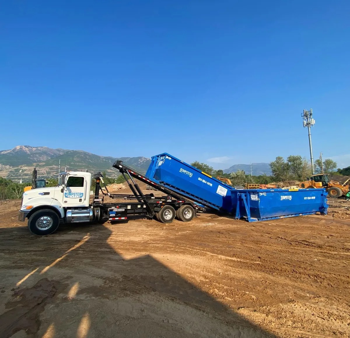 Dumpsters Direct roll off truck delivering a dumpster to a construction site