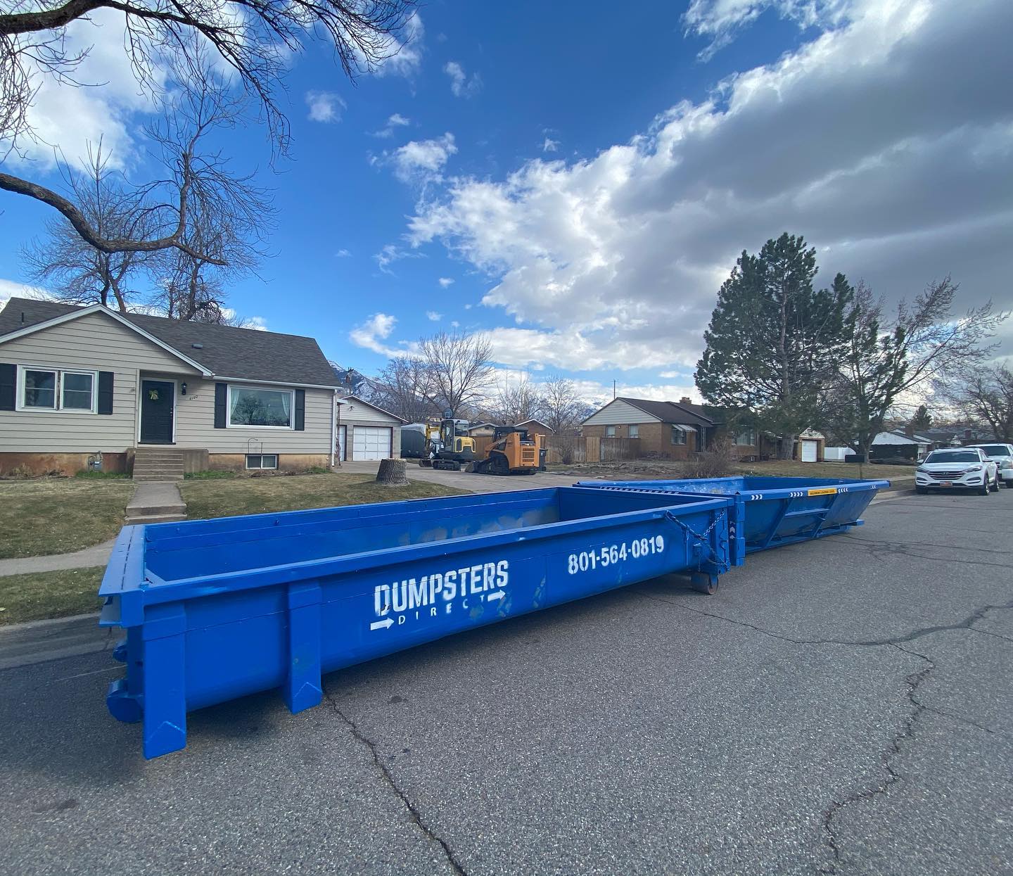 Two Dumpsters Direct roll off dumpsters on a residential street
